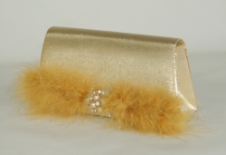 Zlatá společenská kabelka s připnutou ozdobou na přední klopě.