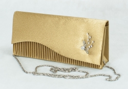 Zlatožlutá společenská kabelka s ozdobnou kovovou broží.